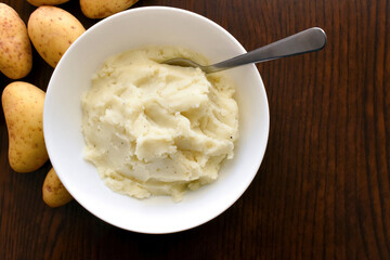 Mashed potatoes in a white bowl. Flat lay top view photo. Food from above concept.	

