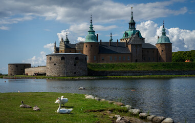Scenic view of white swans sitting on a shore of a lake against Kalmar Castle in Sweden, Europe © Björn Sahlström/Wirestock Creators