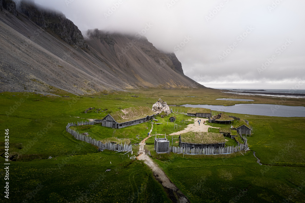 Sticker scenic view of a viking village in iceland surrounded by rocky hills on cloudy weather