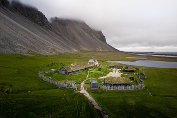 Scenic view of a viking village in Iceland surrounded by rocky hills on cloudy weather