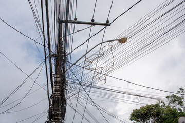Fototapeta premium A mess of cable wires stretched along utility poles that are common throughout Brazil and Latin American Countries