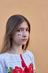 Sad little Ukrainian girl with the flag of Ukraine on her face. The children are asking for peace.
The concept of participation of the Ukrainian people in the war with Russia. No war.
