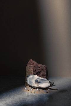 Underwater still life abstract studio photo with rock, sand, pearls, oyster shell,  and shadow light from window