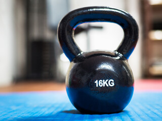 Naklejka na ściany i meble 16 kg kettlebell at a gym. Weight lifting concept.