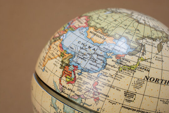 Closeup shot of a globe isolated on a brown background