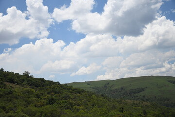 Obraz premium View of fields on the path with white clouds and green land