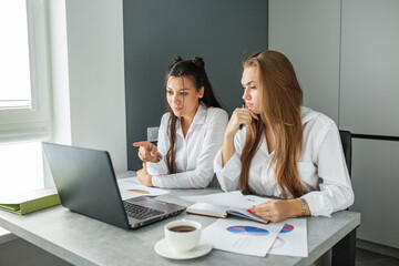 Obraz premium Two female colleagues communicate in office at work. Work place. Use technology and Internet.