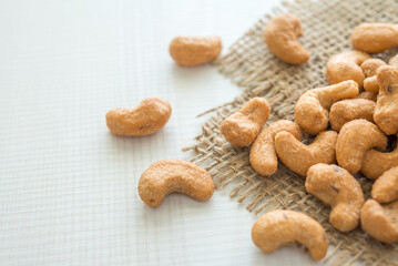 Salted cashew nuts on sackcloth background copy space. Food and nutrition concept.