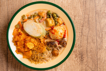 Lontong sayur or vegetable rice cake is an Indonesian traditional rice dish made of pieces of lontong served in coconut milk soup with shredded chayote, tempeh, tofu, hard-boiled egg, sambal, rendang