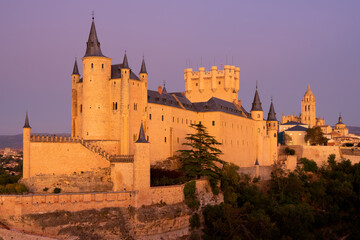 View of the Alcazar fortress and St Mary cathedral of segovia with alpenglow in the background,...