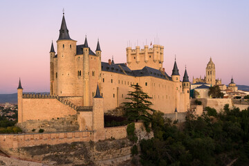 Fototapeta na wymiar View of the Alcazar fortress and St Mary cathedral of segovia with alpenglow in the background, listed world Heritage centre by UNESCO