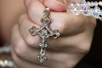 Rosary necklace with a cross in the hand that will be used for prayer.