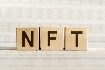 Word NFT non fungible token written on the wood cubes on white background. Non-fungible tokens concept NFT.