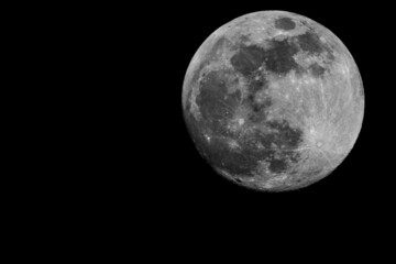 Zoomed in shot of the full moon on the dark night sky