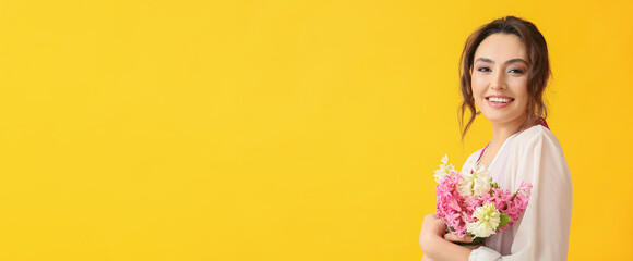 Happy young woman holding bouquet of hyacinth flowers on yellow background with space for text