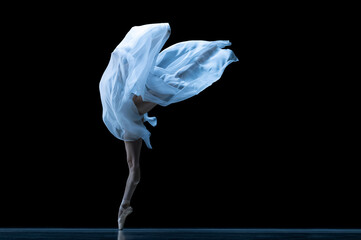 Beauty. Classic ballerina dancing with weightless fabric isolated on black studio background in neon. Theater, art, grace, action and motion concept.