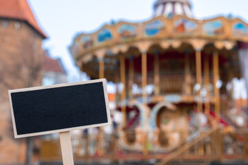 Empty mockup template Blackboard label against Carousel in amusement park. Old-fashioned...