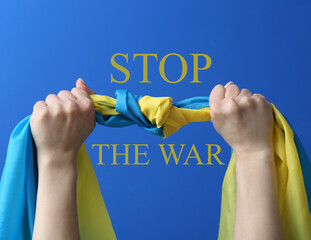 Hands with flag of Ukraine and text STOP THE WAR on blue background