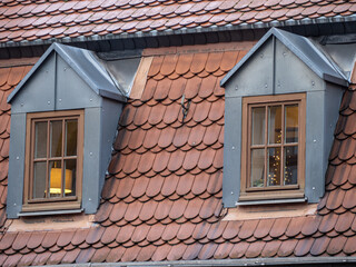 Two dormer windows on a tiled roof building