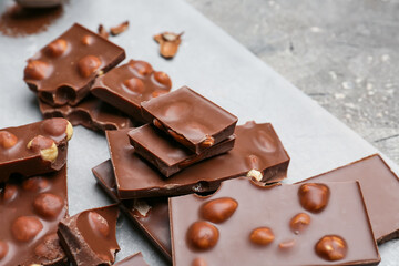 Pieces of tasty chocolate with nuts on table