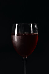 Glass of tasty red wine on dark background