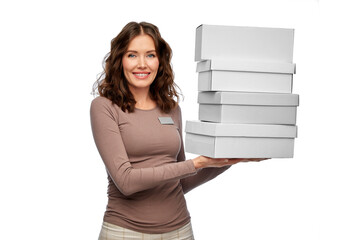 sale, shopping and business concept - happy female shop assistant or saleswoman holding four shoe boxes white background