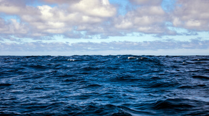 View of the sea and sky landscape with waves in deep ocean waters.