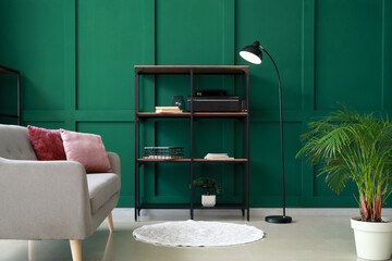 Shelves with decor and floor lamp near green wall in living room