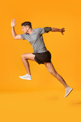 Fototapeta na wymiar Sporty male runner on color background