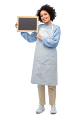 cooking, culinary and people concept - happy smiling woman in apron holding black chalkboard over white background
