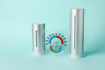 Home weather station and hygrometer on color background