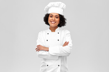 cooking, culinary and people concept - happy smiling female chef in white toque and jacket over...