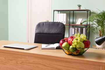 Modern workplace with fruit basket in light office