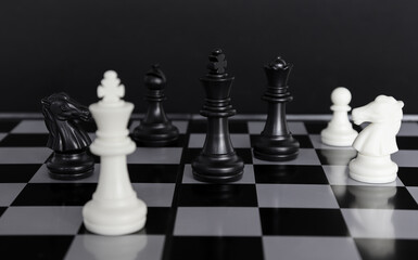 The king in a battle chess game stands on a chessboard with a black isolated background. Business Leadership Ideas.