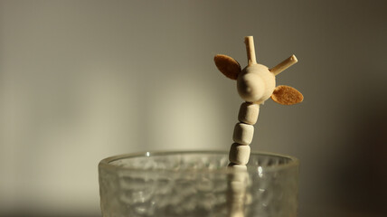 Small wooden giraffe toy in a glass