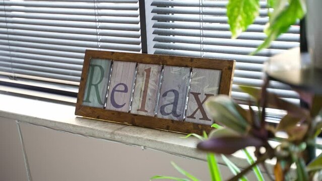 Colorful Wooden Relax Sign Decoration on Bright Office Window.