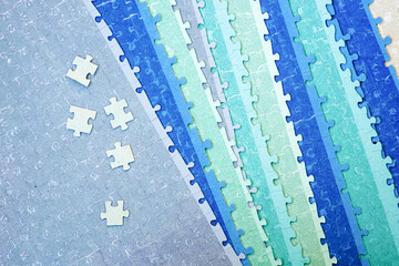 Blue, green, gray puzzle. Single puzzles on assembled jigsaw puzzle background