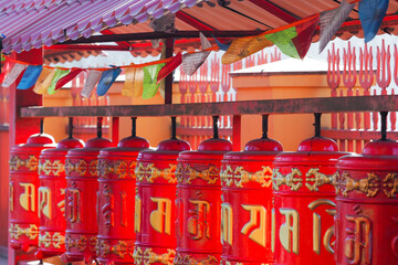 Buddhist prayer flags and prayer wheels at the yard of Datsan Gunzechoinei or Datsan Gunzechoyney. Prayer wheels. Avalokiteshvara mantra "Om mani padme hum"