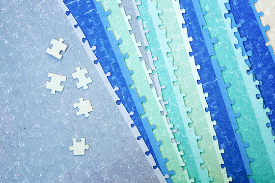 Blue, green, gray puzzle. Single puzzles on assembled jigsaw puzzle background
