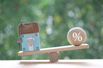 Interest rate up and Banking concept, Model house with percentage symbol icon on wood scale seesaw...