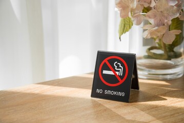 No smoking sign in hotel room with sunlight from curtain window. Healthcare concept.