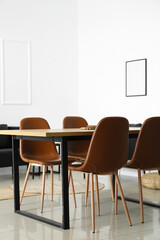 Interior of light dining room with table and modern chairs