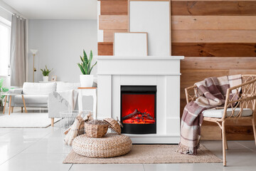 Interior of stylish living room with mantelpiece, firewood and armchair
