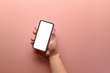 Top view sweet color flat lay of hand holding a smartphone with the white blank screen on a pink background , for communication and technology concept.