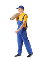 Male worker with rolled carpet on white background