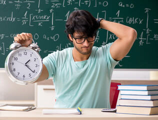 Young male student mathematician in front of chalkboard