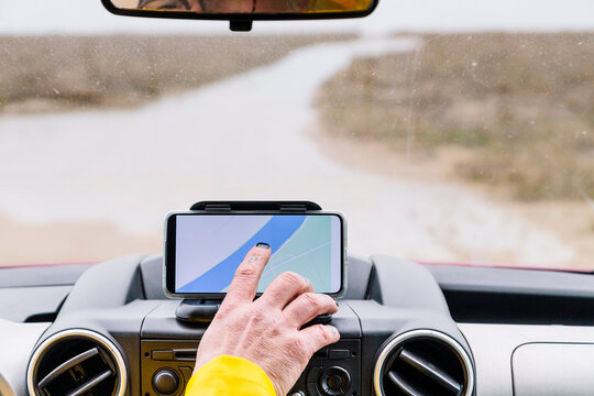 Unrecognizable man turning on GPS in car