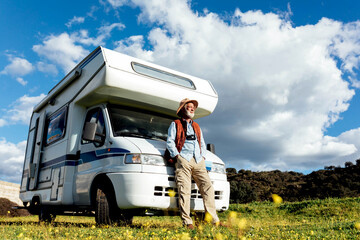 Senior man near camper in nature
