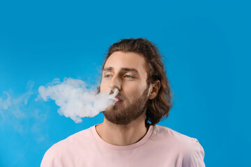 Smoking young man on blue background
