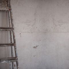 textured concrete wall with old metal ladder